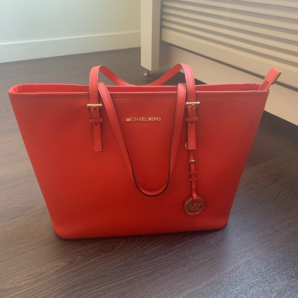 Reddish orange Michael Kors handbag.